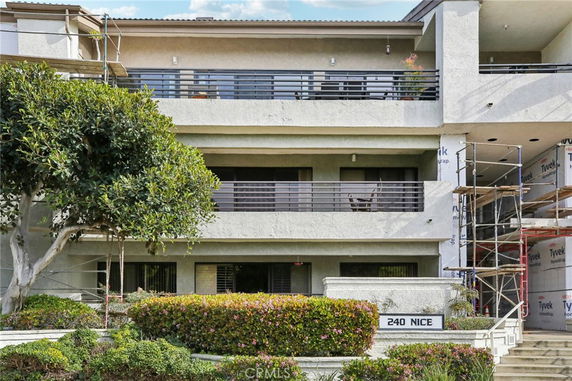 Front view of a multi-story residential building with balconies.