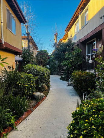Walkway between two residential buildings with greenery.