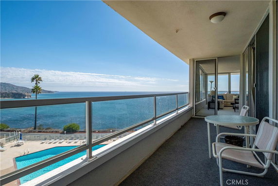 Balcony view overlooking the ocean with outdoor seating.