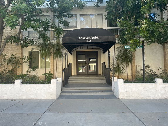 Front view of a multi-story residential building with a covered entrance.
