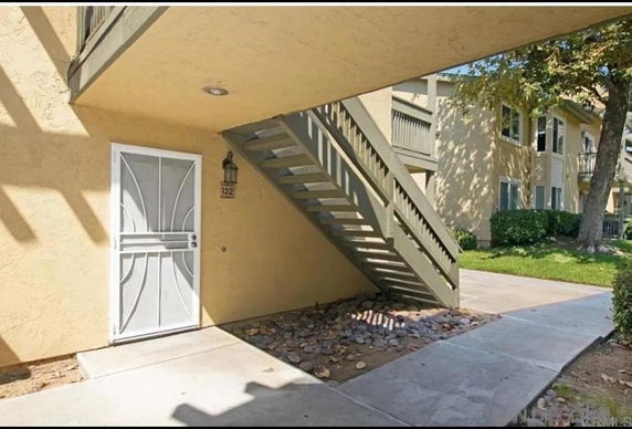 Exterior view of a building entrance with stairs leading to upper levels.