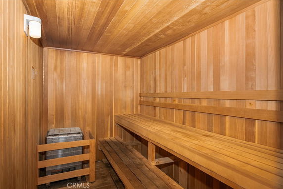 Wooden sauna interior with benches and a heater.
