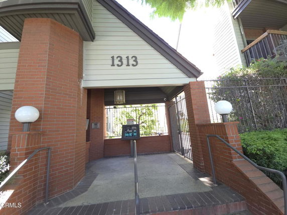 Entrance view of a building with brick pillars and large house number 1313.