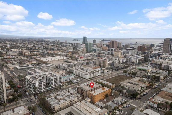 Panoramic view of a cityscape with multiple buildings and a waterfront in the background.