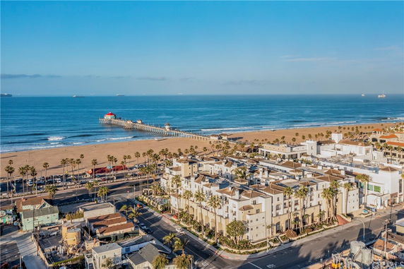 Aerial view of a beachside area with a pier extending into the ocean.