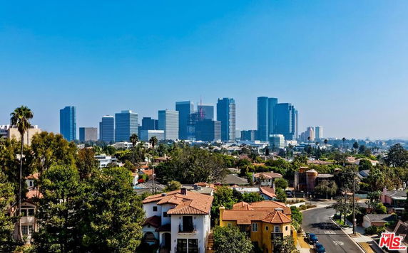 Wide angle view of a cityscape with high-rise buildings and residential area in the foreground.