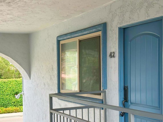 Front view of a building with a blue door and window.