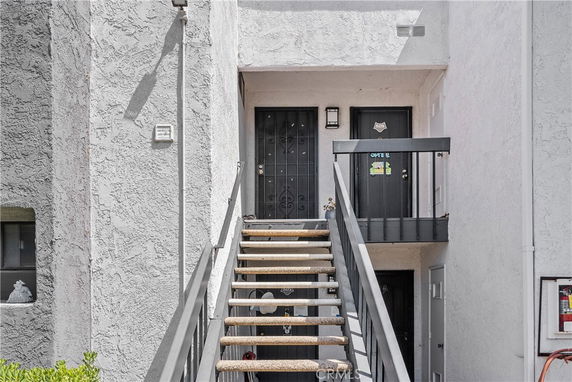 Front view of a two-story building with stairs leading up to the entrance.