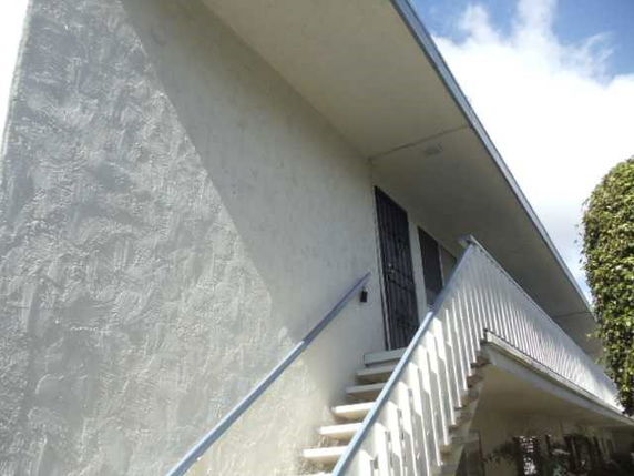 Front view of a two-story building with an external staircase.