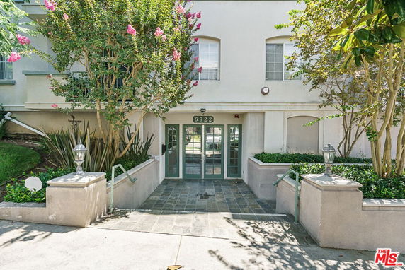 Entrance view of a multi-story building with double doors and green trim.