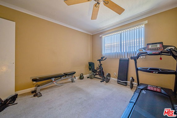 Room with exercise equipment including a treadmill and stationary bike.