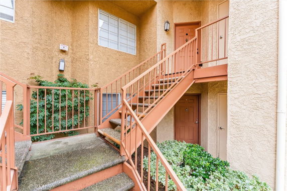 View of a building entrance with stairs leading to a second level.