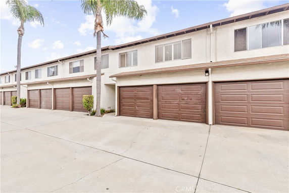 Front view of a two-story apartment building with brown garage doors.