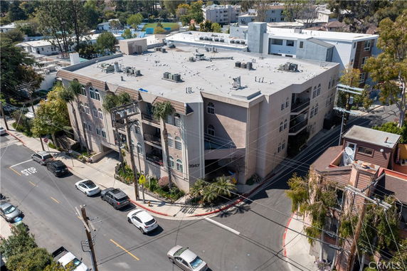 Front view of a multi-story apartment building on a street corner.