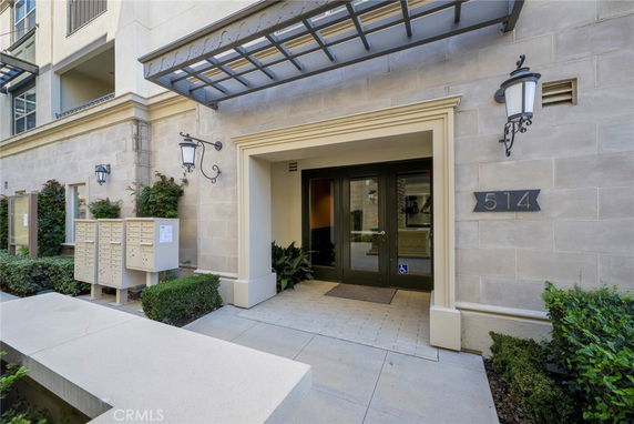 Front entrance of a building with glass doors and mailboxes.