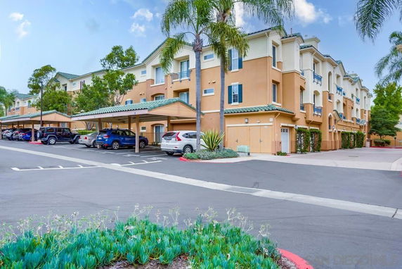 Front view of a multi-story apartment building with covered parking.
