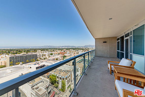 View of surrounding areas seen from the building with balcony and seating area.