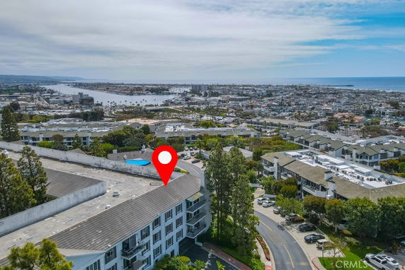 Panoramic view of a residential area with buildings and a water body in the background.