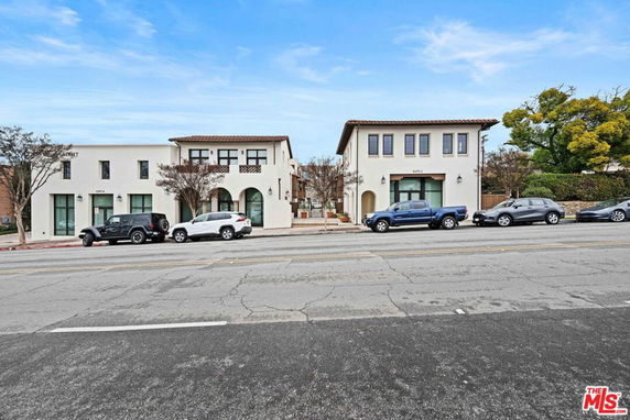 Front view of a building with multiple units and Mediterranean architectural style.