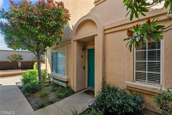Front view of a house with a blue door and two large windows.