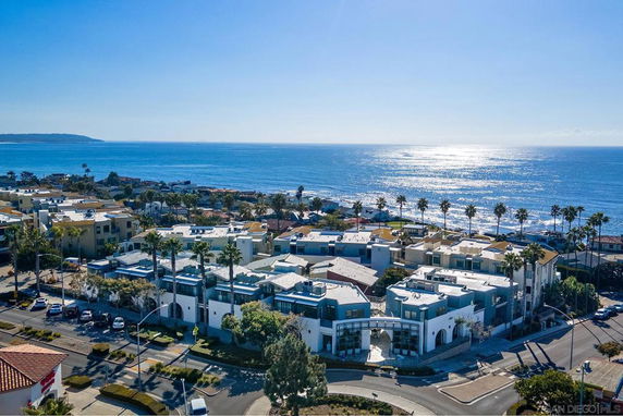 Aerial view of coastal buildings with the ocean in the background.