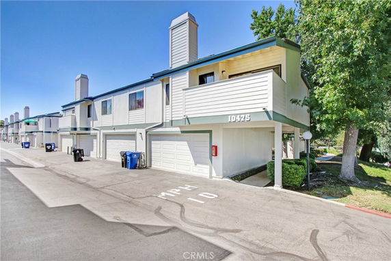 Front view of a two-story townhome building with garages.