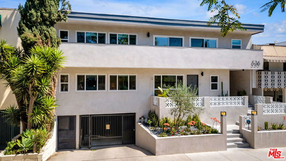 Front view of a two-story building with a modern design and gated entrance.