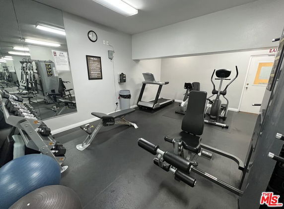 Indoor gym area with exercise equipment including treadmills, elliptical machines, and weights.