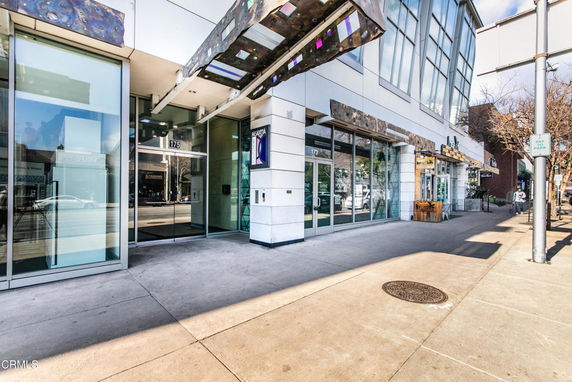 Front view of a commercial building with large glass windows and entrance.
