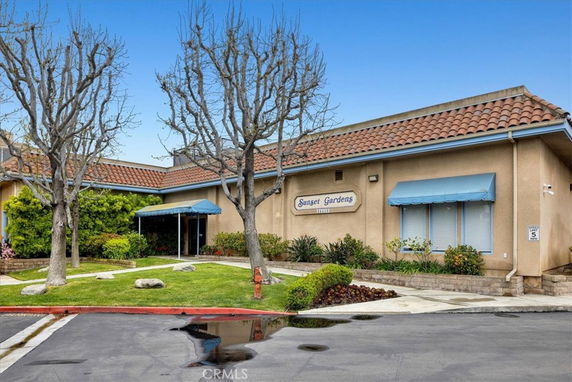 Front view of a single-story building with a tile roof and an entrance with an awning.