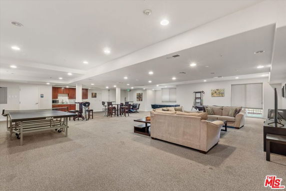 Indoor area with sofas, a table tennis table, and recreational seating.