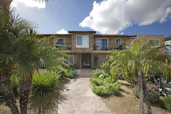 Front view of a two-story house with balcony and stone accents.