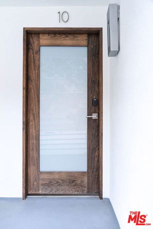 Front view of a modern wooden door with frosted glass and number 10 above it.