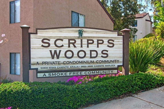 Front view of a condo building with a sign reading 'Scripps Woods.'