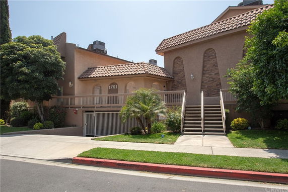Front view of a two-story building with a staircase and entranceway.