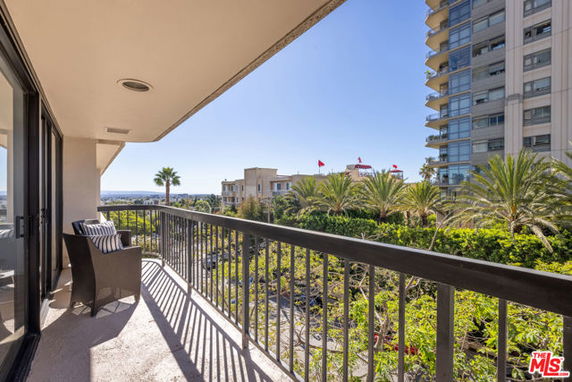 Balcony view overlooking a cityscape with trees and tall buildings.
