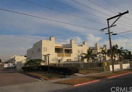 Front view of a multi-story apartment building with a flat roof and balconies.