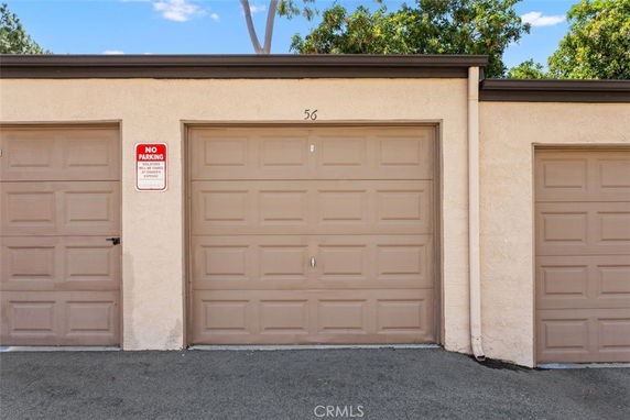 Garage doors with a no parking sign and unit number 56.