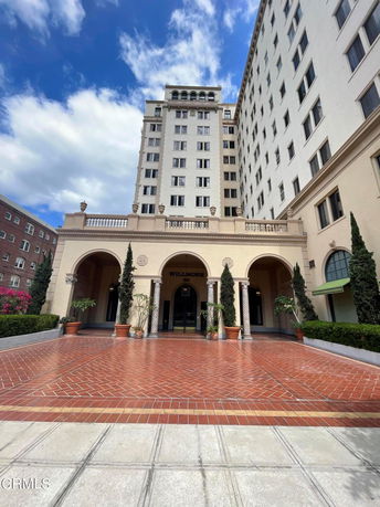 Front view of a multi-story building with an arched entrance.
