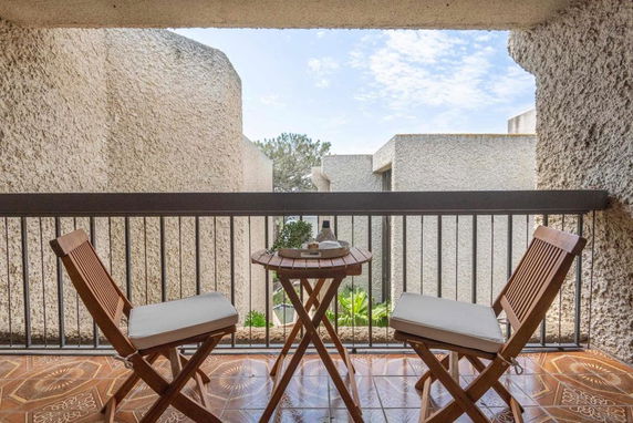 Outdoor view from a balcony with chairs and a table.
