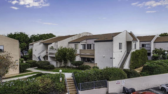 Front view of an apartment building with multiple units and external staircases.