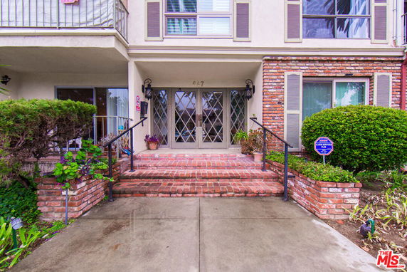 Front view of a two-story house with brick accents and double doors.