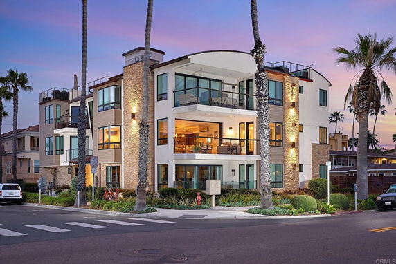 Front view of a modern multi-story building with large windows and balconies.