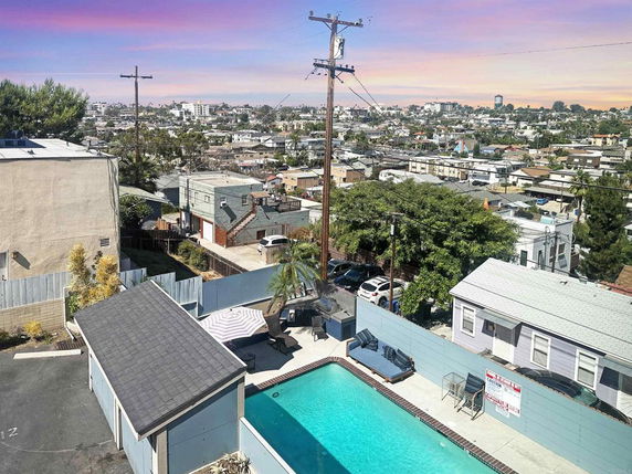 Panoramic view of an urban area with a swimming pool in the foreground and buildings in the background.