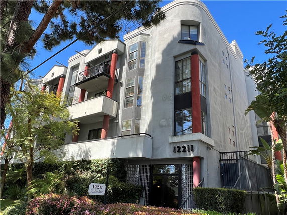 Front view of a multi-story building with balconies and large windows.