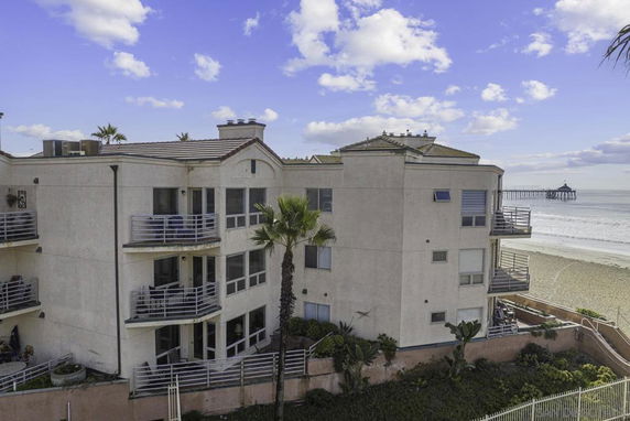 Exterior view of a multi-story beachfront building with balconies.