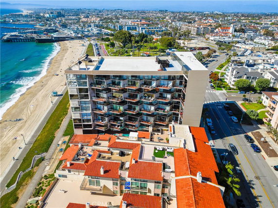 Aerial view of a beachfront building with balconies and a beach nearby.