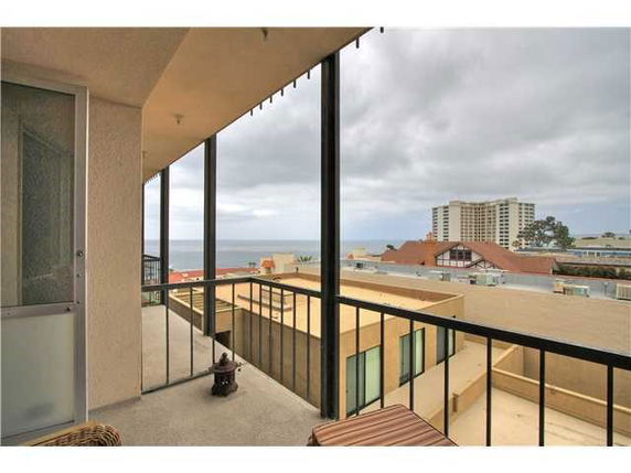 Balcony view overlooking buildings and the ocean.