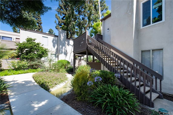 Front view of a building with external staircase and landscaped pathway.