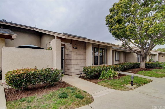 Front view of a single-story house with a walkway and well-maintained landscaping.